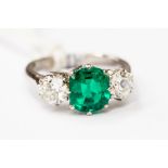 An emerald and diamond ring, the cushion cut Columbian emerald claw set, weighing approx 1.42carats,
