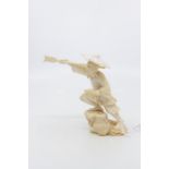 An early 20th century Japanese ivory okimono of a fisherman with spear and basket at feet, 11.5