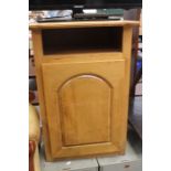 A light oak bedside cupboard.