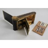 An early 20th Century camera shaped ladies vanity compact with music box, manicure set and mirror