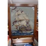 A tilt top table with a glazed wool work panel depicting a galleon.