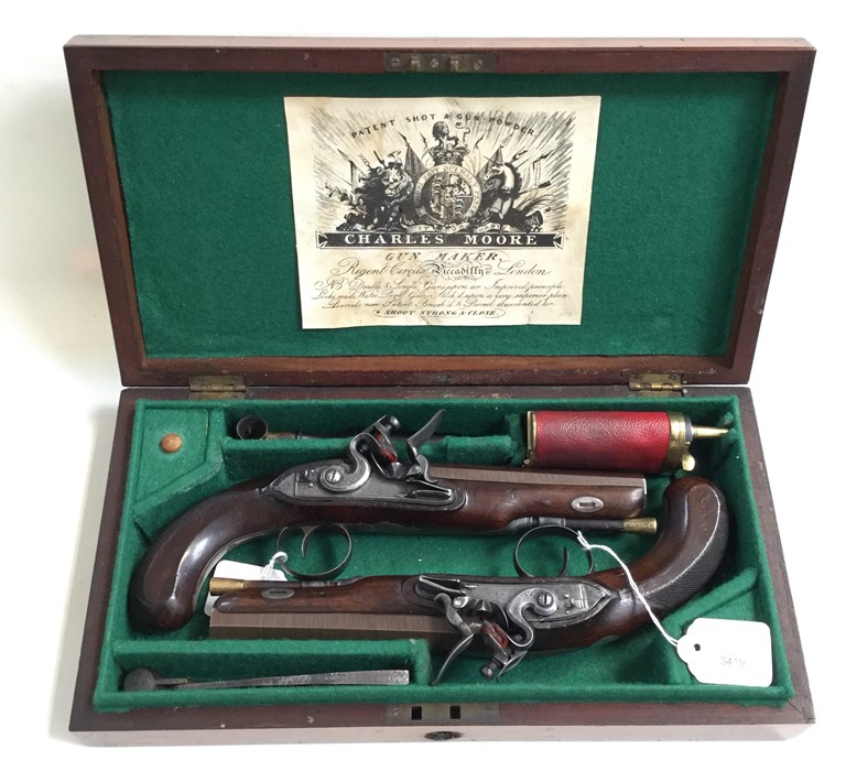 A cased pair of Flintlock pistols by Charles Moore. 15cm long octagonal rifled barrels, marked "