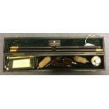A Holland & Holland Shotgun cleaning kit comprising of a black leather covered wooden box containing