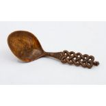 Treen, a folk art fruit wood love spoon, interlaced fretwork handle with padlock finial, the bowl