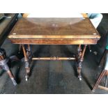 A Victorian burr walnut fold-over carved table, circa 1860, raised on turned support, carved