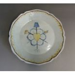 A faience armorial plate decorated with a heart and crossed swords, circa 1789, 24cm diameter