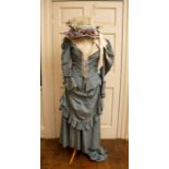 A reproduction theatrical light blue 1970 dress, draped over skirt wide cream lapels & leg o