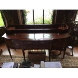 A George III mahogany sideboard, of breakfront form, with bowed end sections, with a hinged