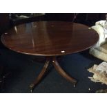 A George III style mahogany pedestal dining table, of circular form, complete with an extra leaf,