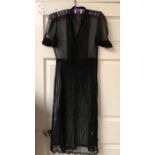 a black chiffon 1930's cocktail dress with puff sleeves and covered buttons the skirt has strips