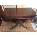 A George III mahogany folding tea table, circa 1820, folding twisted top above a turned collumn on