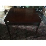 A George III mahogany folding tea table, circa 1800, folding top raised turned tapered supports with