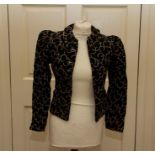A black quilted jacket late 1930's floral coloured half rings decorate the jacket, Peter Pan