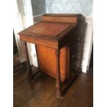 A mid Victorian oak Davenport desk, the upper section with a stationary compartment, the leather