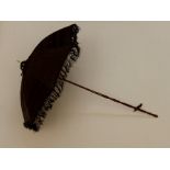 A black silk parasol with a fold up handle carved sticks with silk tassle with a Ivory finial (