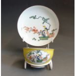 A Meissen yellow ground tea bowl and saucer, painted with a bird sitting in a Pine branch