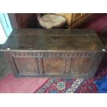 A 17th Century joined oak chest, plank lid, carved arcaded frieze, three panelled front, panelled