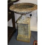 A pair of late 19th Century cast iron garden pedestal urns, raised on tapered plinths, height