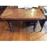 A William IV mahogany dining table with two additional leaves raised on turned support on brass