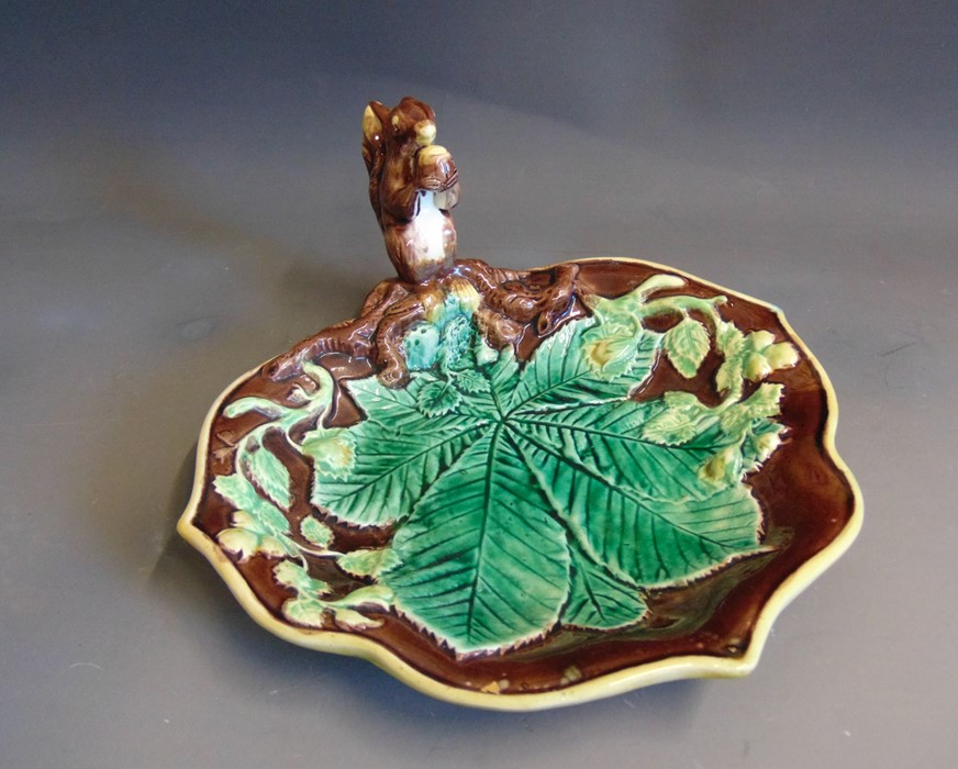 A continental Majolica leaf shaped nut dish, the handle is a squirrel sat holding a nut, brown