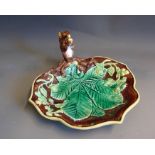 A continental Majolica leaf shaped nut dish, the handle is a squirrel sat holding a nut, brown