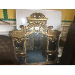 A late 19th Century gilt framed over-mantle mirror, in the Rococo Revival style, have swan neck