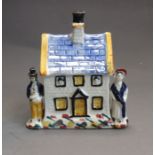 A Prattware pottery money box in the form of a cottage, circa 1820, 12cm high, 11cm wide