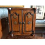 An Edwardian novelty oak smoker's compendium, in the form of a safe, fitted interior with drawers