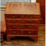 A George I walnut bureau, the fall front enclosing a fitted interior of drawers and pigeon holes,