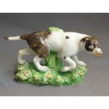 A Staffordshire pearlware model of a pointer, standing on a grassy base, circa 1820, 16cm wide,  9cm