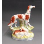 An unusual Staffordshire figure of a hunting dog standing four square above a recumbent deer,