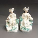 A pair of Staffordshire pastoral, seated figures of a Shepherd and Shepherdess, white and gilt with