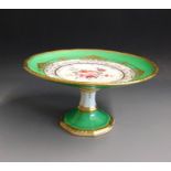 A Royal Crown Derby comport, green ground, the centre painted with flowers and raised gilt