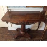 An early 19th Century rosewood veneered fold-over pedestal tea table, the top raised on a circular