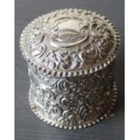 A late 19th century silver circular tea caddy, repousse embossed all over flower and 'C' scroll
