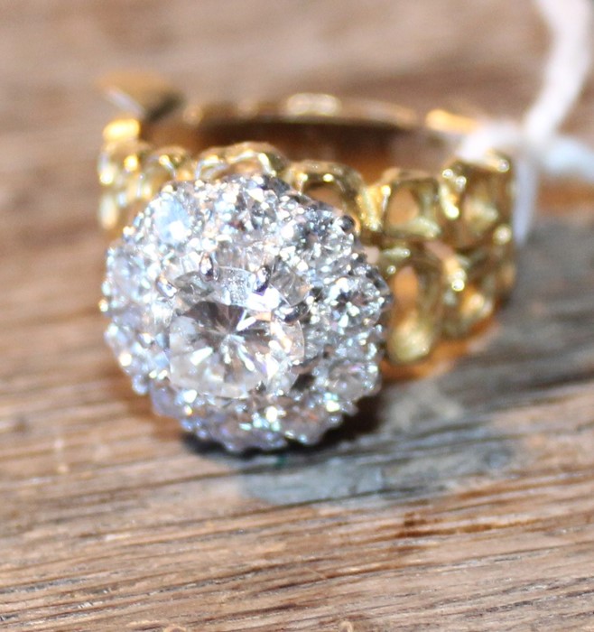 An 18ct. gold and diamond cluster ring, set central round brilliant cut diamond (approx weight 1.