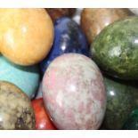 A large collection of polished stone eggs, to include; malachite, agate, red jasper, banded