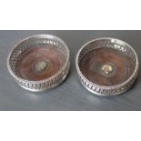 A pair of silver plated champagne coasters, each with pierced side, gadrooned rim and turned wood