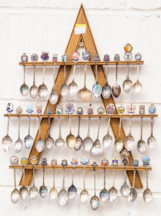 **AWAY** A collection of white metal tourist souvenir spoons, on stand