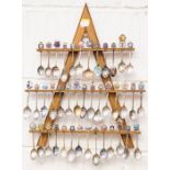 **AWAY** A collection of white metal tourist souvenir spoons, on stand