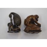 A  Japanese dark wood Netsuke which depicts a large bird and a small dog, the bird has its beak in a