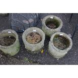 A set of four concrete garden planters.