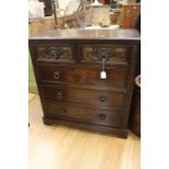 A 1970's dark oak small chest of drawers with carved decocation to two top drawers.