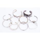 A collection of ten silver bangles, various design s including torque and hinged versions, one