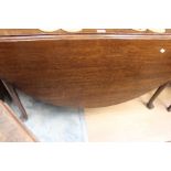 A George II oak drop leaf table, raised on turned legs with pad feet