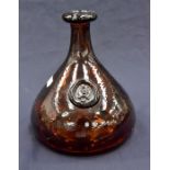 A brown moulded glass onion shaped bottle with bearded mask seal