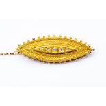 A Victorian 15ct gold mourning brooch, Etruscan style marquise shaped with five graduated diamonds