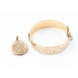 A 9ct rolled gold bangle set with red stones; and a Victorian rolled gold locket (2)
