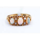 A Victorian 18ct gold opal and diamond ring, comprising three oval opals with diamond set accents,