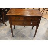 An early Victorian Lowboy in Oak, with square tapered legs on platform feet. Two smaller drawers and